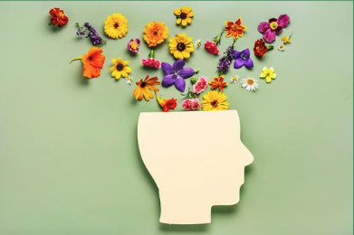 a stylized image of a featureless silhouette with colorful flowers coming from its head