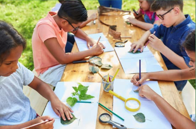 photo of young children doing crafts at a picnic table